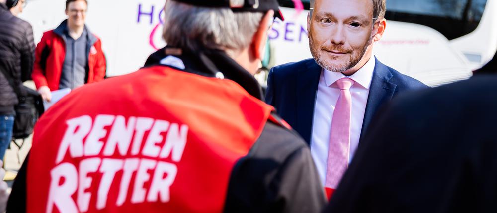Eine Person trägt vor dem FDP-Bundesparteitag bei einem Protest der IG Metall gegen die Aktienrente eine Maske des FDP-Bundesvorsitzenden Lindner. 