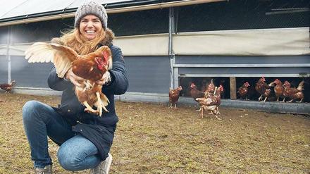 Fröhliches Flattern. Karoline Hesterberg vor ihrem mobilen Hühnerstall. Rund 1000 Hennen picken auf Gut Hesterberg das ganze Jahr Futter auf der Wiese. Im Stall wandern die frisch gelegten Eier aufs Band.