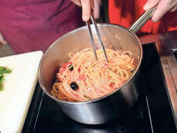 „Pasta nach Puttanesca-Art“ mit Tomaten, Kapern, schwarzen Oliven und Sardellenfilets.