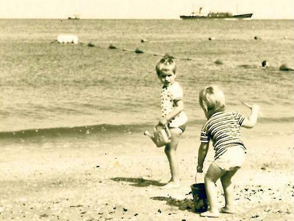 Sommer 1970. Unsere Autorin (mit Gießkanne) und ihre Schwester am Strand. Damals schien immer die Sonne.