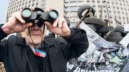 Ein pro-russischer Demonstrant bewacht Barrikaden in Donezk.