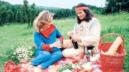 Freizeitindianer. Bei Elspe im Sauerland macht Pierre Brice in den 80ern ein Picknick mit seiner Frau Hella. Dabei sein Winnetou-Kostüm zu tragen, war eine Idee des Fotografen.