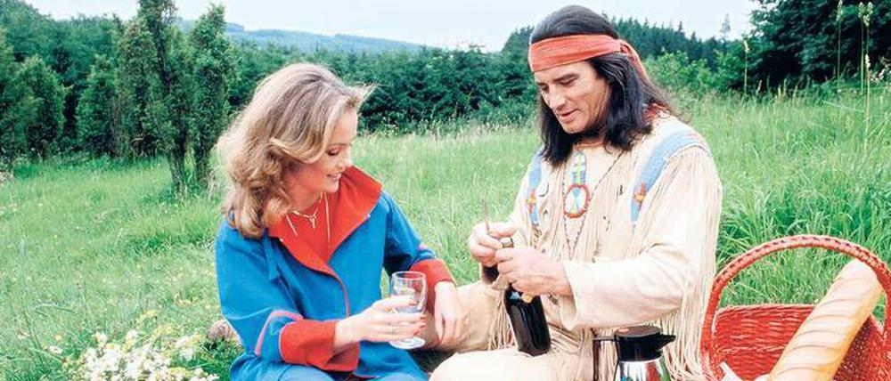 Freizeitindianer. Bei Elspe im Sauerland macht Pierre Brice in den 80ern ein Picknick mit seiner Frau Hella. Dabei sein Winnetou-Kostüm zu tragen, war eine Idee des Fotografen.