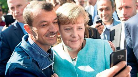 10. September 2015: Bei ihrem Besuch an der Außenstelle des BAMF am Askanierring in Spandau machen einige Flüchtlinge Selfies mit Angela Merkel. Der Autor dieses Selfies, der Iraker Schakir Kedida, äußert sich seitdem immer wieder zur Kanzlerin: Bis heute positiv. 