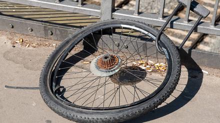 Nur noch das Hinterrad eines Fahrrads ist mit einem Fahrradschloss an das Geländer einer Berliner Brücke gekettet. 