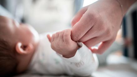 Ein Baby klammert sich an den Finger seiner Mutter. (Symbolbild)
