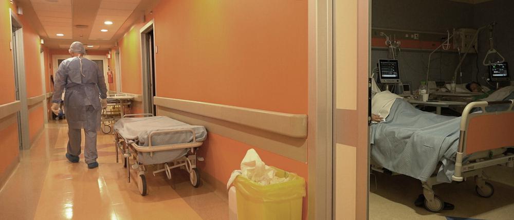 Ein medizinischer Angestellter geht einen Krankenhausflur entlang (Symbolbild).