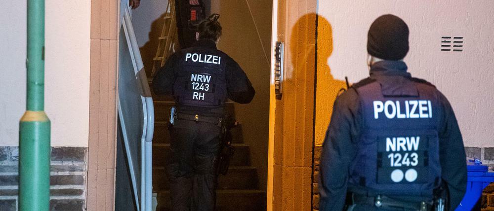 Einsatzkräfte der Polizei durchsuchen ein Mehrfamilienhaus in Essen.