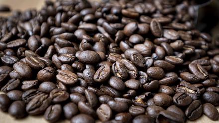Geröstete Kaffeebohnen liegen auf einem Tisch. Der ohnehin hohe Kaffeekonsum in Deutschland ist auf Rekordniveau gestiegen.