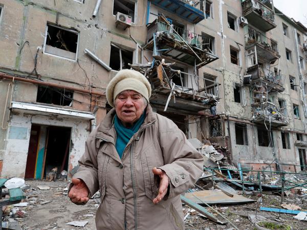 Eine Einwohnerin von Mariupol steht vor einem schwer beschädigten Wohnblock. Der Bürgermeister rechnet mit 21.000 Toten.