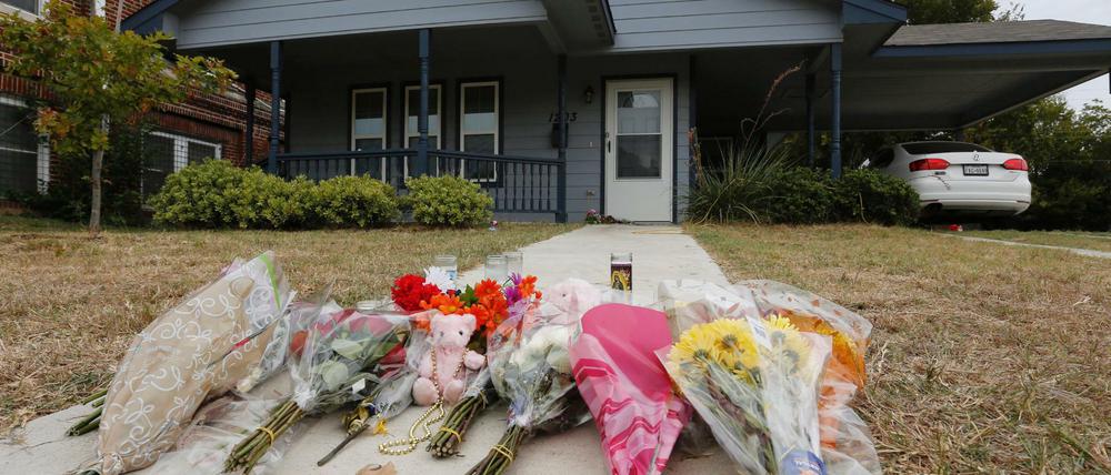 Blumen liegen vor dem Haus, indem eine 28-Jährige erschossen worden ist.