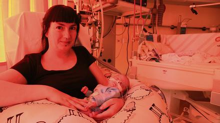 Mutter Ina Seiler, mit ihrem Sohn Lennert auf dem Arm vor dem Inkubator.