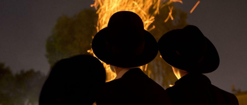 Orthodoxe Juden versammeln sich in Israel an einem Lagerfeuer während eines jüdischen Festes.