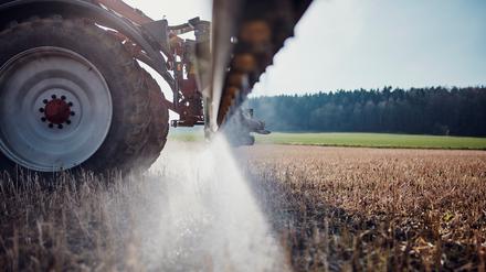 Ein Traktor bringt mittels einer gezogenen Anhängespritze zur Saatbettbereinigung Glyphosat aus.