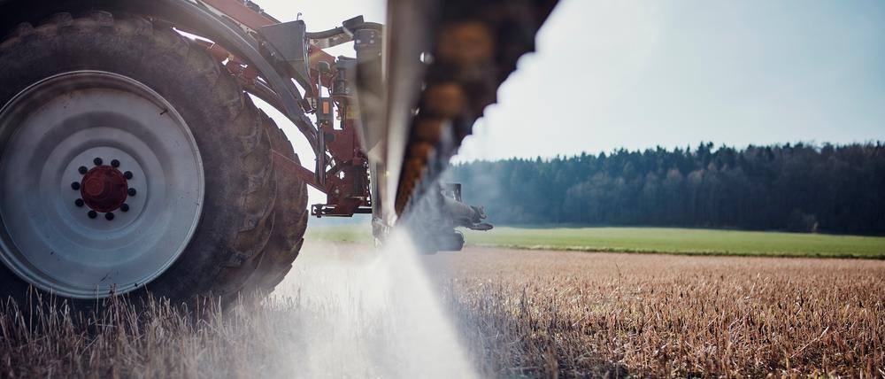 Ein Traktor bringt mittels einer gezogenen Anhängespritze zur Saatbettbereinigung Glyphosat aus.