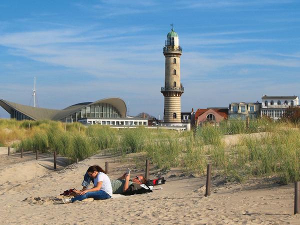 Mit dem Leuchtturm und dem Teepott im Rücken, kann man am Strand von Warnemünde bestens entspannen.
