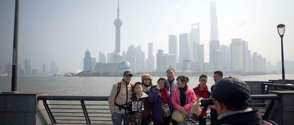 Eine Gruppe Touristen vor der Skyline von Pudong in Shanghai.