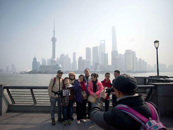 Eine Gruppe Touristen vor der Skyline von Pudong in Shanghai.