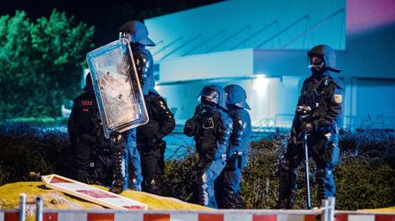 Polizisten stehen am Abend des 23.08.2015 vor dem ehemaligen Praktiker-Baumarkt in Heidenau (Sachsen) auf der Straße. Bei Protesten von Anwohnern und Rechtsextremen gegen eine neue Flüchtlingsunterkunft war es hier zu Ausschreitungen gekommen.