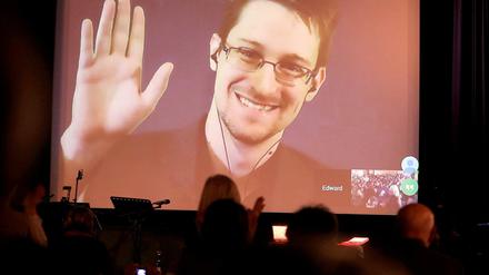 Der NSA-Enthüller Edward Snowden winkt während einer Videoschalte dem Publikum zu. Der US-Whistleblower Edward Snowden ist Vater geworden, das Foto ist aus dem Jahr 2014.