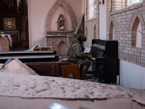 Paradies in der Hölle. Militärseelsorger Mark Kupchenenko spielt in einer zerstörten Kirche Klavier. Das Foto wurde am ersten Weihnachtstag aufgenommen.
