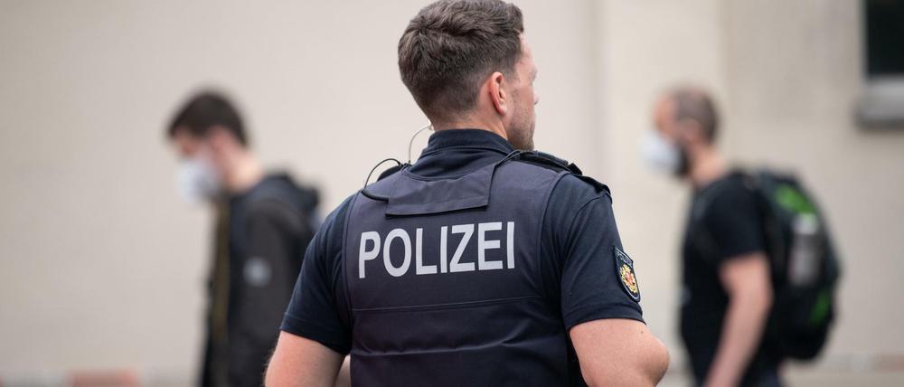 Ein Polizist steht vor dem Gymnasium in Bremerhaven: Einsatzkräfte der Polizei begleiten die Schülerinnen und Schüler aus der Schule.