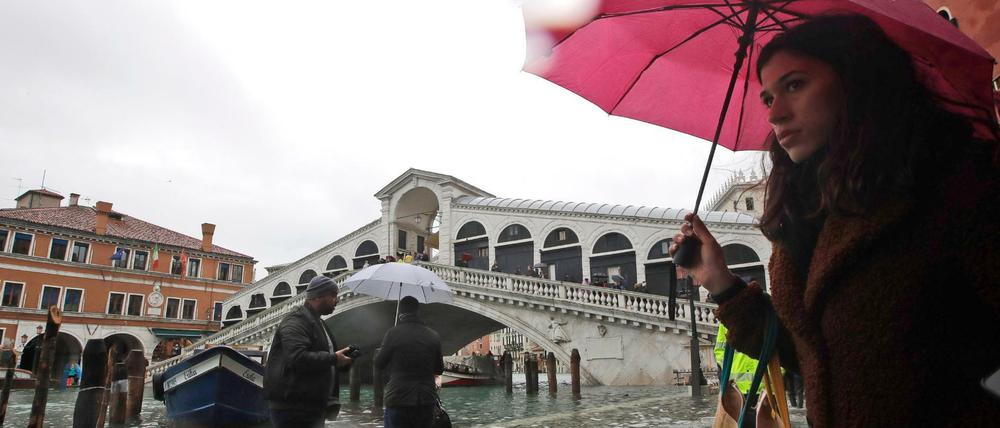 Passanten waten in der Nähe der Rialto-Brücke durch das Hochwasser in Venedig.