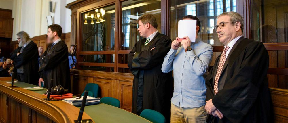 Die Angeklagte Hamdi H. (2.v.r) und Marvin N. (5.v.r, halb verdeckt) stehen im Landgerichtes Berlin zwischen ihren Anwälten. 