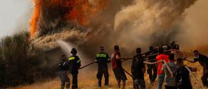 Feuerwehrleute und Freiwillige versuchen ein Feuer in Afidnes, etwa 30 Kilometer von der griechischen Hauptstadt Athen entfernt, zu löschen. 