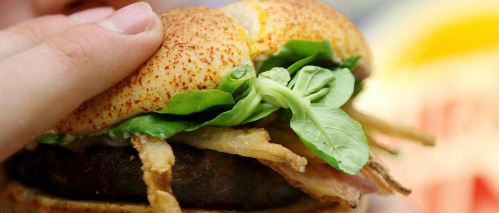 Ein Kunde isst in der Fast-Food-Kette Burger King einen Burger (Archiv).
