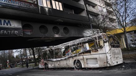 03.01.2023, Berlin: Ein ausgebrannter Reisebus steht nach Krawallen in der Silvesternacht vor einem beschädigten Wohnhaus im Berliner Bezirk Neukölln. Foto: Fabian Sommer/dpa +++ dpa-Bildfunk +++