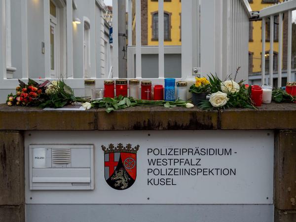 Blumen liegen und Kerzen stehen am Eingang der Polizei in Kusel.