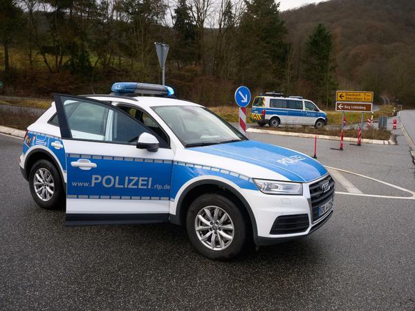 Polizeibeamte sperren die Zufahrt zum Tatort in Kusel.