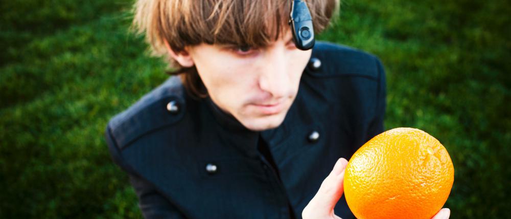 An seinem Hinterkopf trägt der farbenblinde Neil Harbisson einen Chip, heraus ragt eine schwarze Antenne mit einem optischen Sensor, der die Farben einfängt. Beispielsweise die einer Orange. 