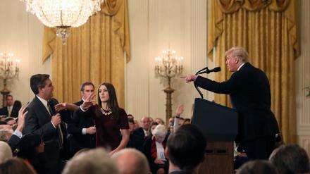 Dreikampf. Während der Auseinandersetzung zwischen CNN-Reporter Jim Acosta (links) und US-Präsident Donald Trump versucht eine Mitarbeiterin des Weißen Hauses, Acosta das Mikrofon wegzunehmen.