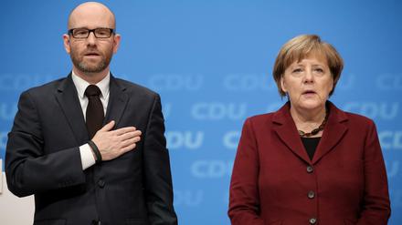 Die Bundeskanzlerin und CDU-Vorsitzende Angela Merkel und der CDU-Generalsekretär Peter Tauber singen am 15.12.2015 zum Abschluss des CDU-Bundesparteitages in Karlsruhe (Baden-Württemberg) die Nationalhymne. 