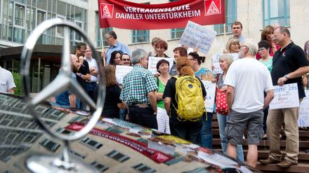 Demonstranten stehen vor dem Landgericht in Stuttgart. Anlass für den Protest ist eine Klage des Autoherstellers Daimler gegen denSüdwestrundfunk wegen einer Reportage über Dumpinglöhne in einem Werk des Autobauers. 