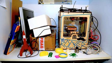 "Maker Bot" sieht nicht gerade nach Hightech aus, doch er ist ein echter 3-D-Drucker. Philip Steffan hat ihn selbst gebaut nach einem Bauset der Firma MakerBot aus Brooklyn. Die Rakete, die grüne Krake und die anderen Objekte im Bildvordergrund sind Ausdrucke.
