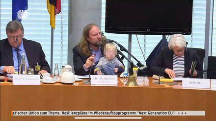 Anton Hofreiter spricht während der Sitzung und hat dabei seinen Sohn auf dem Schoß. 