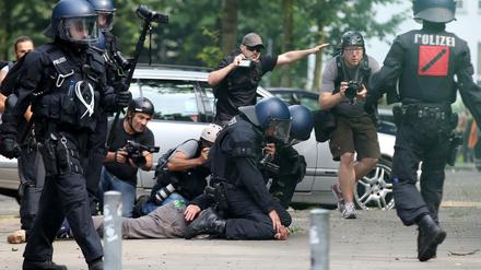 Polizisten nehmen am Freitag nahe der Landungsbrücken einen Aktivisten fest - Journalisten beobachten das Geschehen.