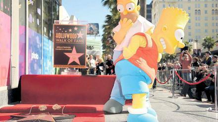 Homer und Bart Simpson machen sich darüber lustig, dass ihr Erfinder Matt Groening einen Stern auf dem „Walk of Fame“ in Hollywood bekommt. 