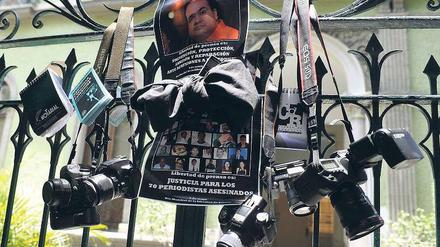 Nach dem Mord an drei Fotografen fordern deren Kollegen mit einem besonderen Trauergebinde an einem Regierungsgebäude in Mexiko City die Behörden zum Handeln auf. Foto: pa