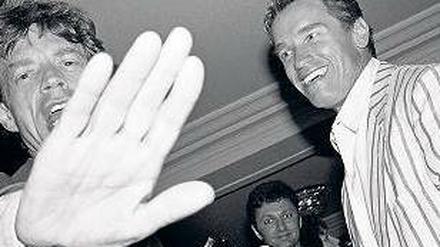 Mick Jagger und Arnold Schwarzenegger halten die Paparazzis 1990 in Antibes auf Abstand.