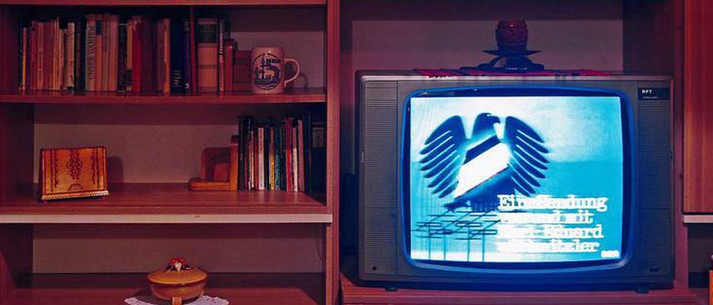 Schrankwand, RFT-Farbfernseher, Montag. Die Eingangssequenz vom „Schwarzen Kanal“ wirkte wie eine Endlosschleife im Fernsehen der DDR.