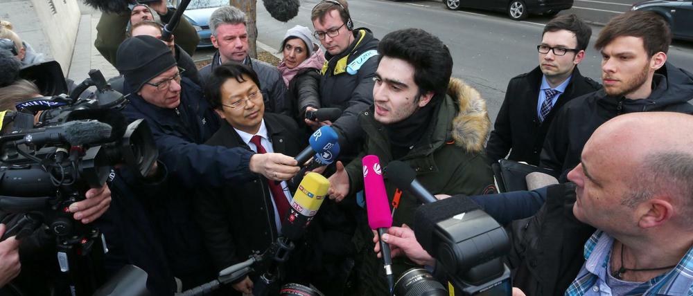 Anas M. (Mitte) spricht vor dem Landgericht Würzburg neben seinem Rechtsanwalt Chan-jo Jun (Mitte links) zu Journalisten.