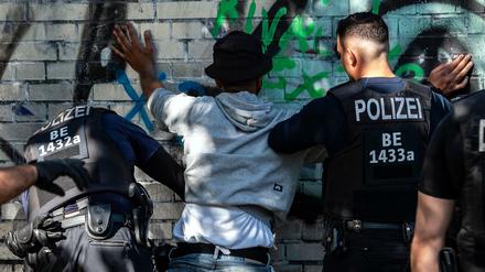 September 2019: Berliner Polizeibeamte kontrollieren in einem Park einen Mann mit dunkler Hautfarbe als mutmaßlichen Drogendealer. 