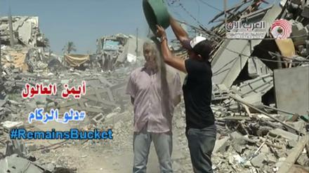Der palästinensische Journalist Ayman al-Aloul in Gaza kippt sich einen Eimer voll Schutt über den Kopf. 