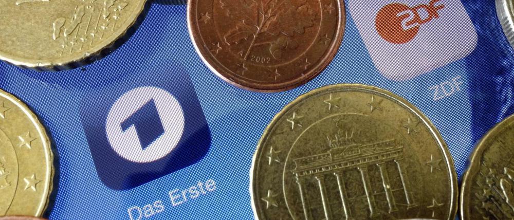Euromünzen liegen neben den Logos der Apps von ARD und ZDF.
