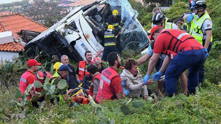 Feuerwehrleute befreien Passagiere aus dem Unglücksbus in Madeira. ARD und ZDF reagierten am Donnerstag mit Sondersendungen auf das Unglück, das 29 Menschen das Leben kostete, darunter wohl hauptsächlich deutsche Touristen. 