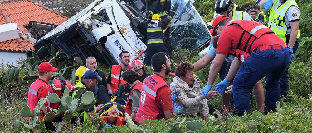 Feuerwehrleute befreien Passagiere aus dem Unglücksbus in Madeira. ARD und ZDF reagierten am Donnerstag mit Sondersendungen auf das Unglück, das 29 Menschen das Leben kostete, darunter wohl hauptsächlich deutsche Touristen. 